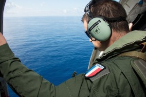 Handout picture provided by the French Army shows a French military transport crew member inspecting the Indian Ocean during a search mission along the coast near Saint-Andre on the French island of Reunion